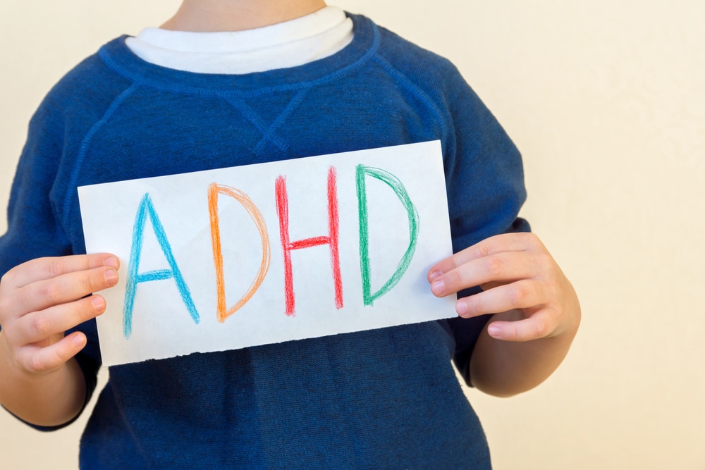 Young boy holds an ADHD sign.