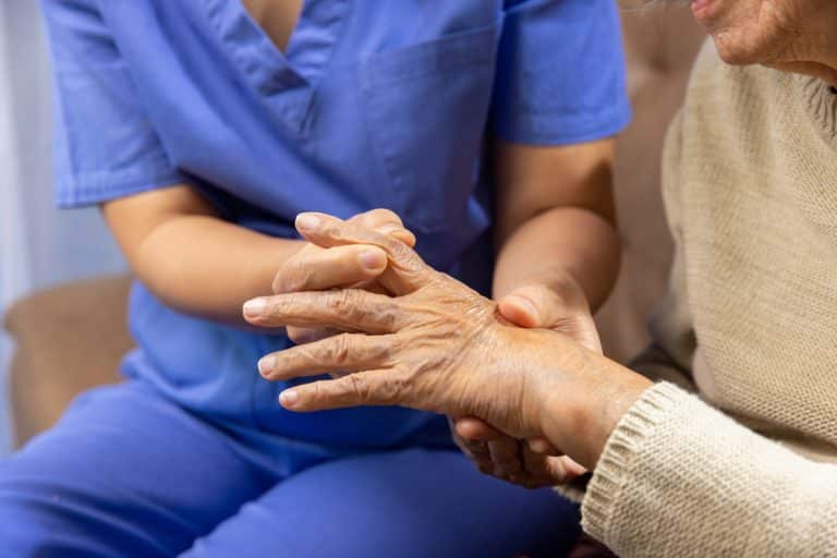 Doctor helping elderly patient with hand pain